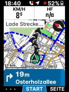 Photo of an ELEMNT screen: a just-pushed route loading (“Lade Strecke…”) while the unit already announces the next turn, 19 m to Osterholzallee.